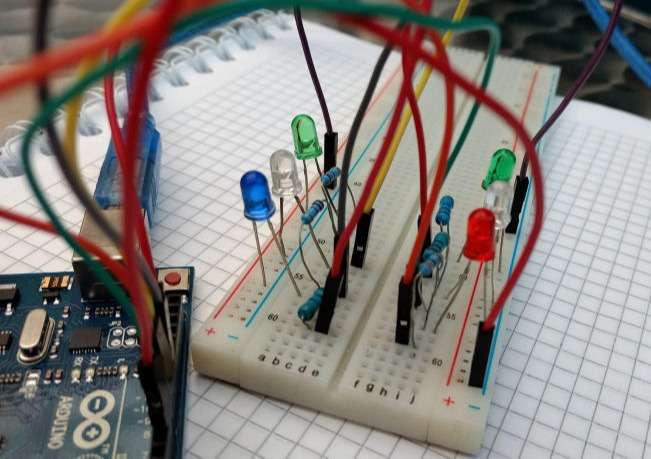 electronic prototyping board with wires and LEDs sticking out